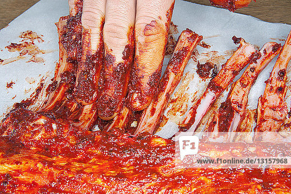 Einreiben der Spareribs mit Marinade