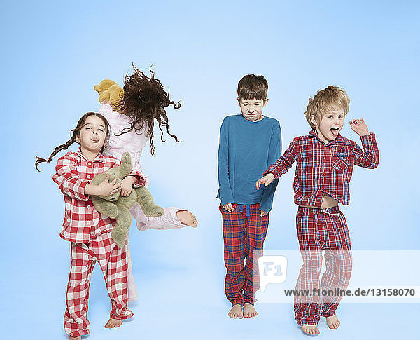 Kinder im Pyjama tanzen und springen
