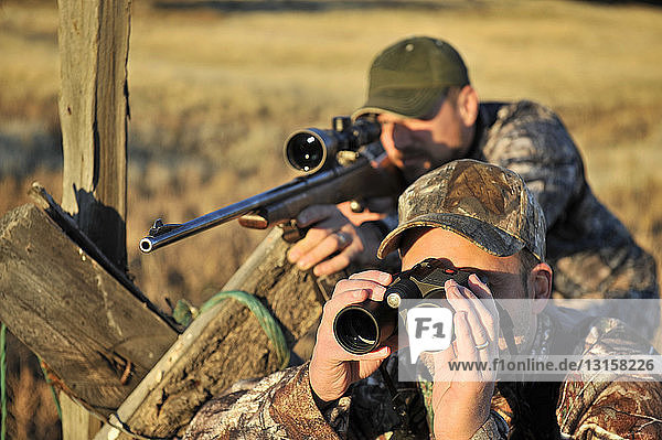 Two deer hunters with rifle and binoculars John Day Oregon USA