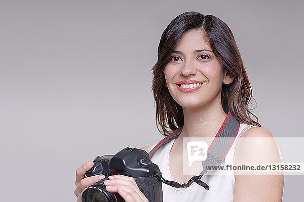 Junge Frau mit digitaler Spiegelreflexkamera