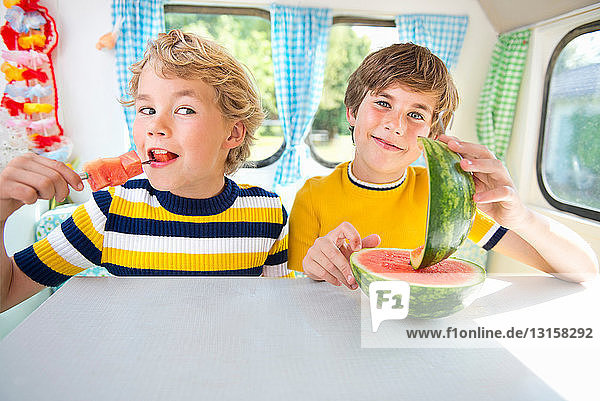 Boys eating watermelon in caravan  portrait