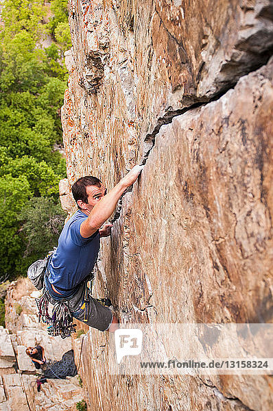 Rock climber scaling boulder crack