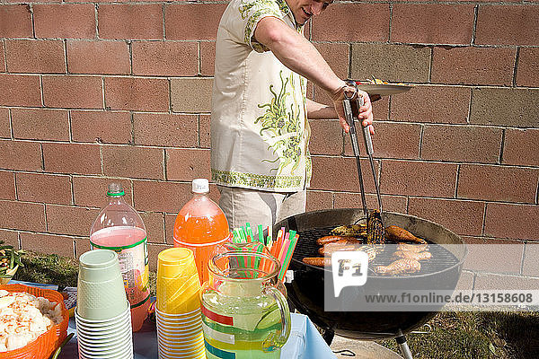 Mann kocht Essen draußen auf dem Grill