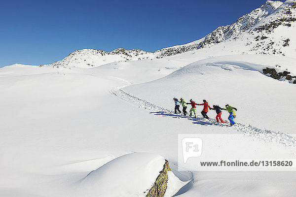 Freunde  die sich gegenseitig im Schnee bergauf ziehen  Kuhtai  Österreich