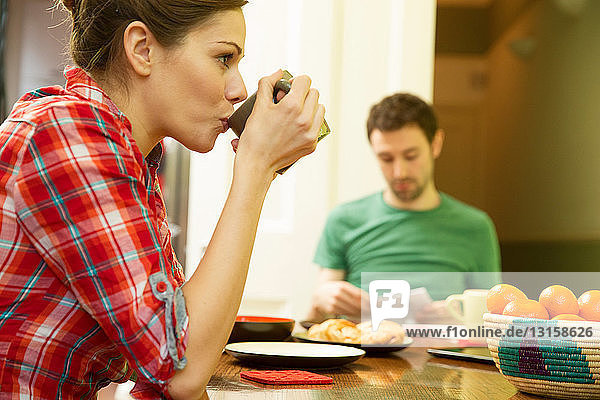 Young couple at breakfast  woman drinking coffee