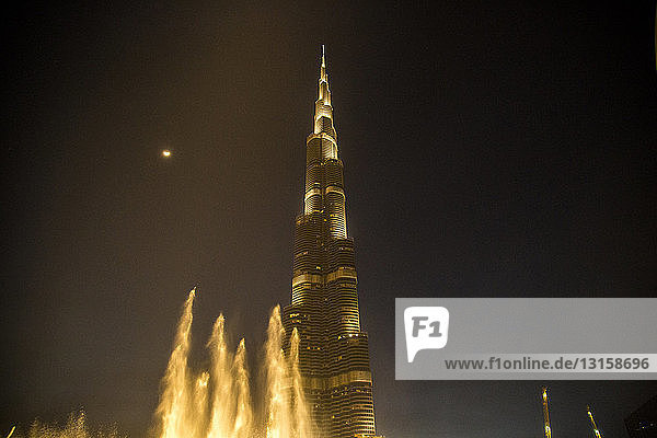 Niedriger Blickwinkel auf die Dubai-Fontänen und den Burj Khalifa bei Nacht  Dubai