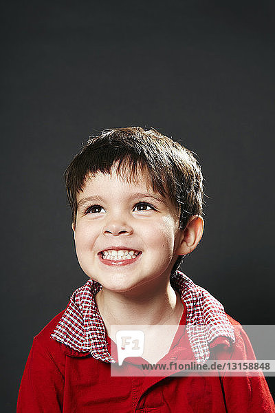 Portrait of young boy  smiling  looking away
