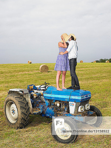 Couple kissing on top of tractor