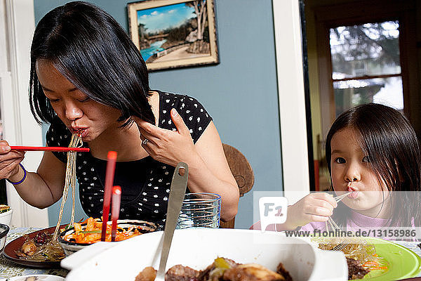 Mother and daughter eating meal