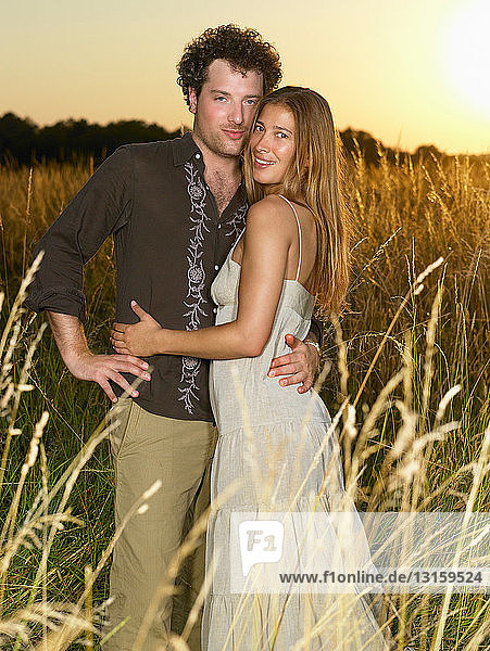 Couple at sunset  in a field