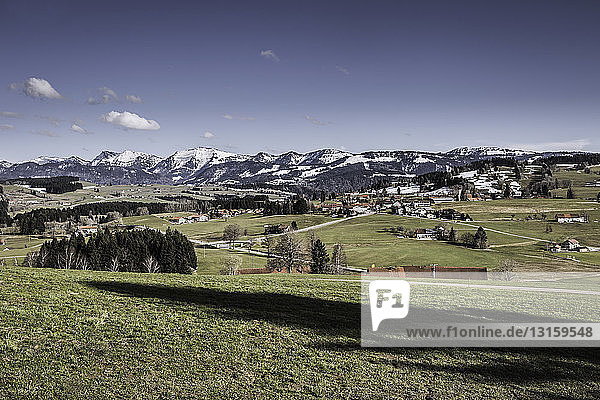 Landschaft mit entfernten schneebedeckten Bergen  Allgäu  Deutschland