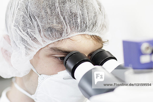 Wissenschaftlerin mit Mikroskop im Labor
