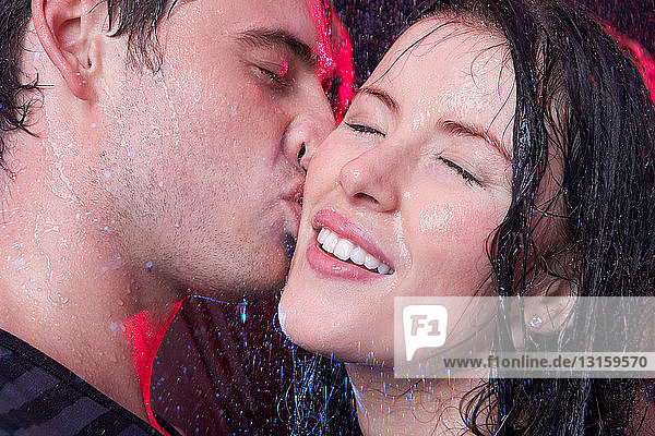 Junges Paar  das sich im Regen küsst