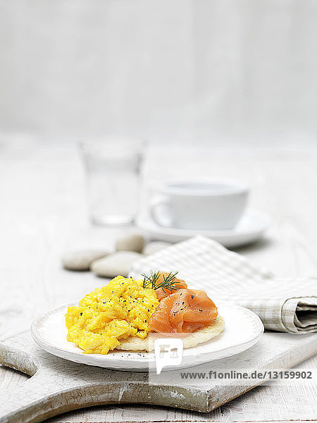 Smoked salmon and scrambled eggs on blini garnished with dill
