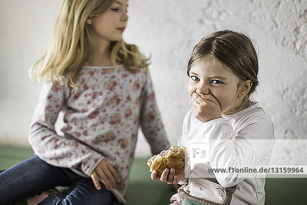 Zwei junge Mädchen essen ein herzhaftes Brötchen