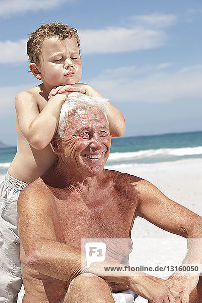 Older man with grandson on beach