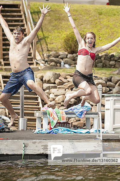 Junges Paar springt in den See