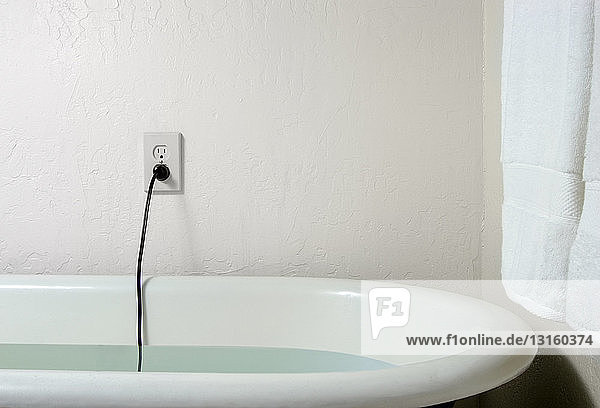 Live plug and cable in bath water