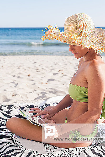 Frau benutzt Tablet-Computer am Strand