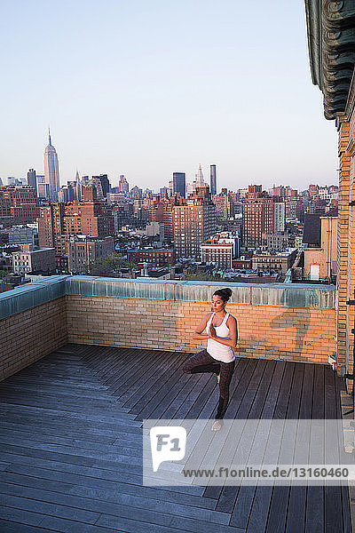 Woman practising yoga on rooftop