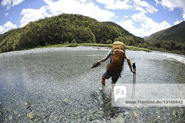 Mid adult woman wading through water  New Zealand