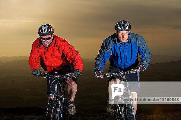 Two mountain bikers riding together.