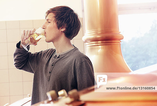 Young man tasting beer in brewery