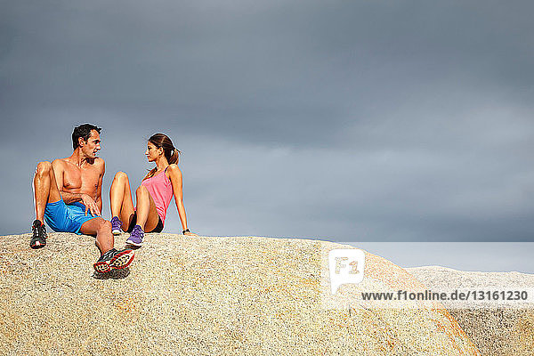 Paar sitzt auf Felsblock