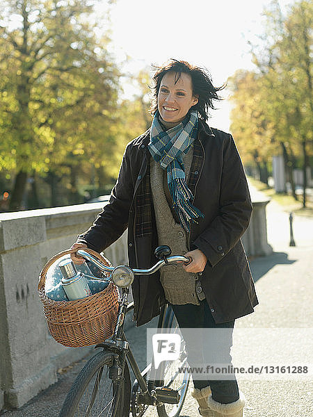 Woman with bicycle on bridge in Autumn