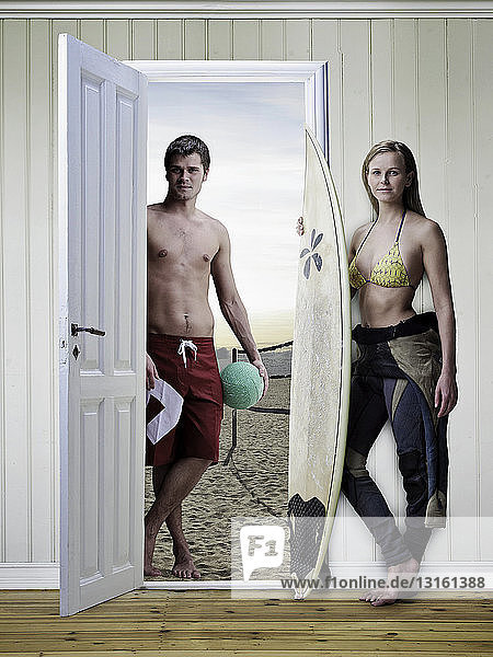 Ehepaar mit Surfbrettern im neuen Haus