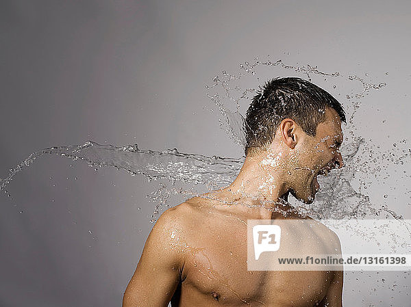 Mann mit Wasser bespritzt