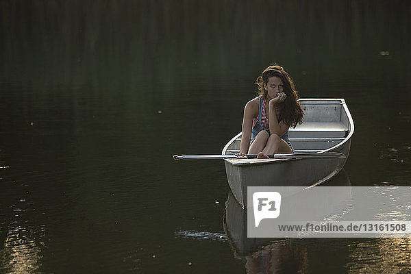 Jugendliche Mädchen fahren abends Boot