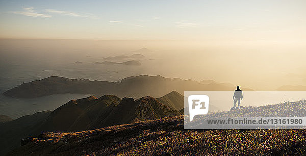 Rear view of hiker hiking on Lantau Peak  Lantau Island  Hong Kong  China