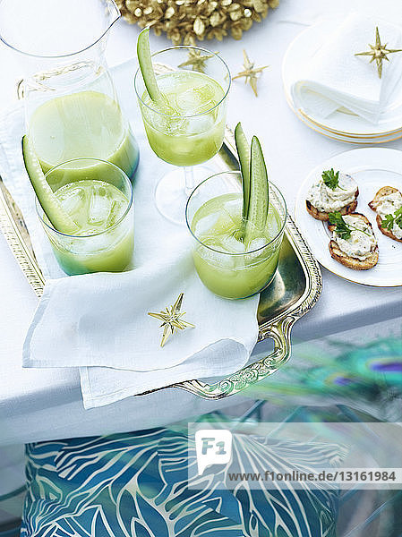 Tray of cucumber agua fresca drinks on decorated table