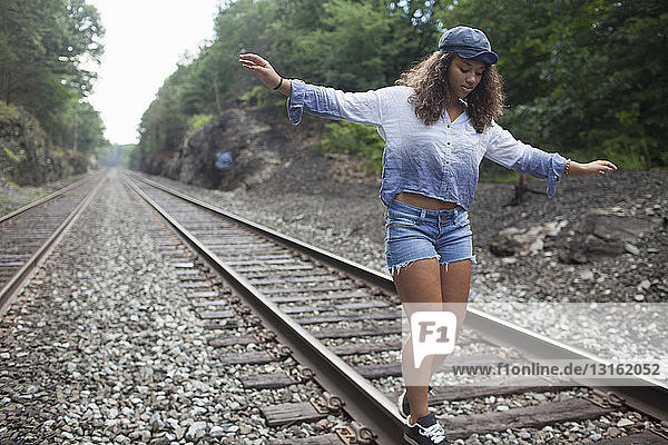 Teenager-Mädchen geht auf Eisenbahnschienen