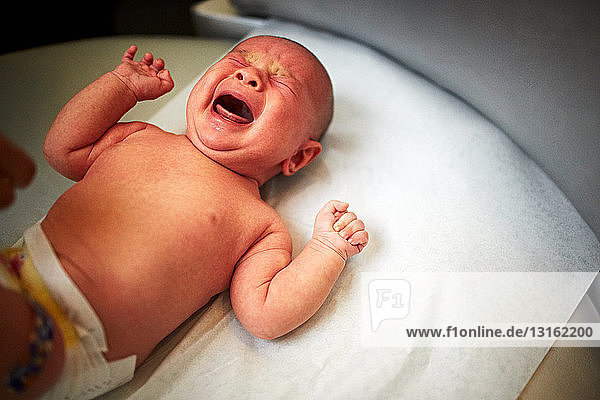 Neugeborenes Baby Junge weint