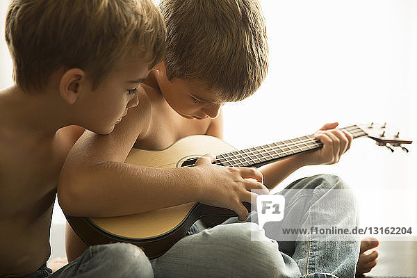 Brüder spielen zu Hause Gitarre