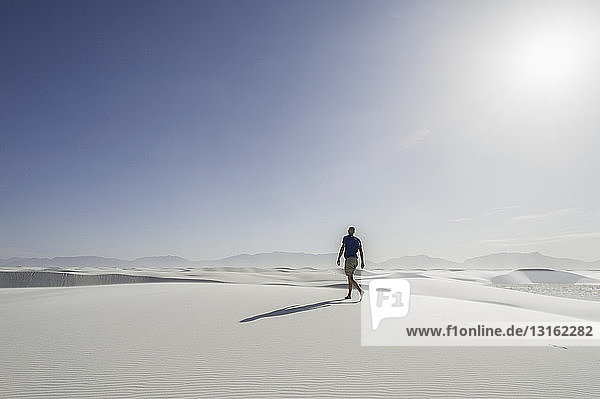 Young man walking on sand dune  White sands  New Mexico  USA