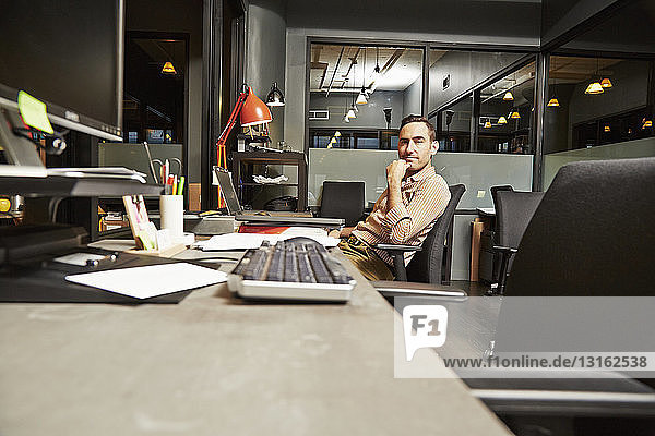Portrait of businessman sitting at desk in office