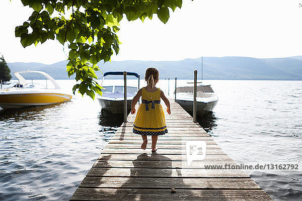 Female toddler exploring pier Silver Bay New York USA