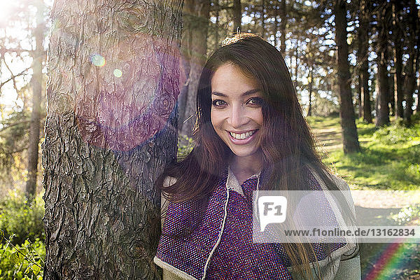 Porträt einer jungen Frau im sonnenbeschienenen Wald