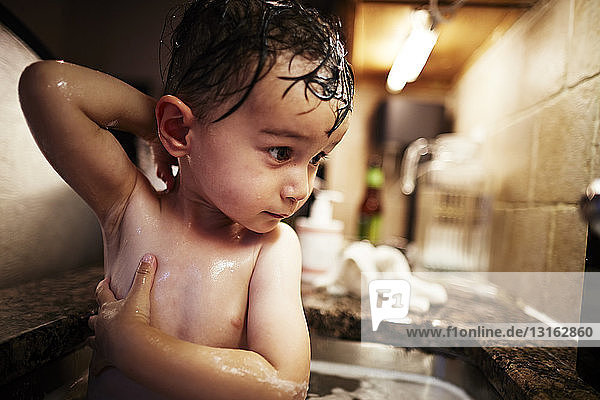 Junge badet im Waschbecken