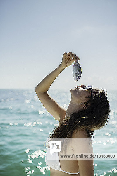 Young woman holding fish above mouth  Islamorada  Florida Keys  USA