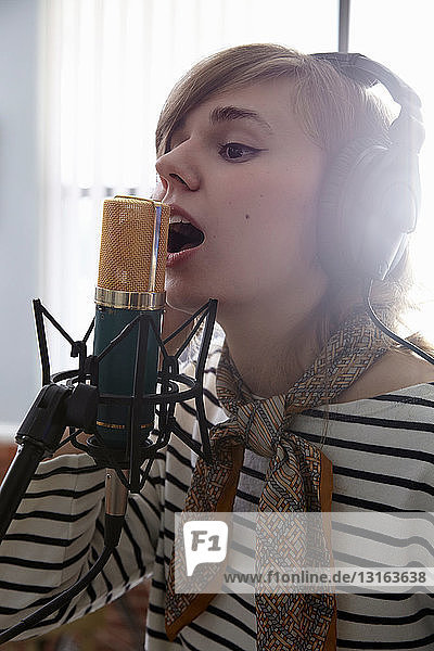 Young woman singing into microphone
