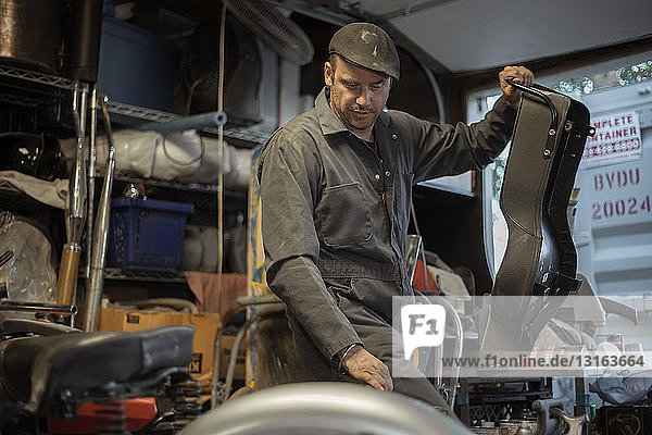 Mechanic in his garage converting gas powered motorcycles to Bio-Diesel