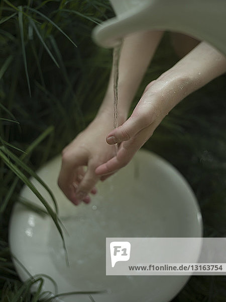 Junge Frau beim Händewaschen unter fließendem Wasser  Nahaufnahme