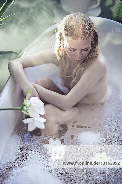 Nackte junge Frau  die sich in der Badewanne entspannt  erhöhte Ansicht
