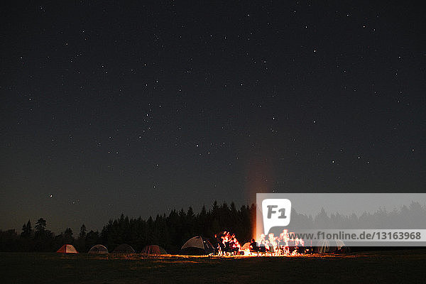 Group of campers sitting around campfire at night  Koppert  Washington  USA