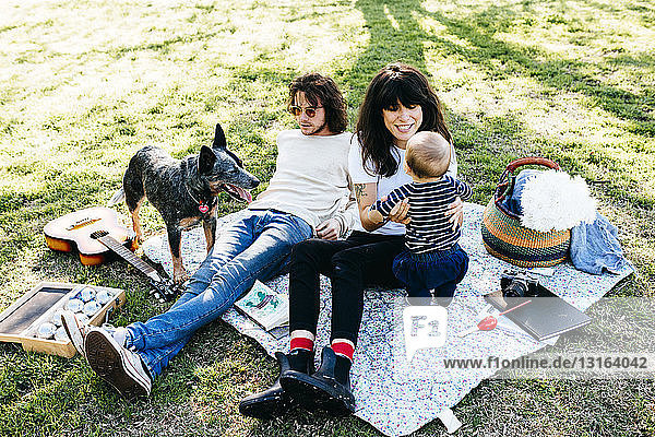 Ehepaar mit Baby auf Picknickdecke im Park