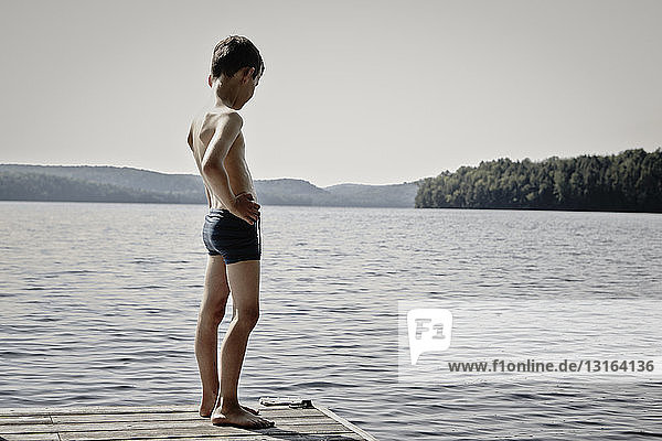 Junge schaut vom Holzsteg auf den See  Ontario  Kanada